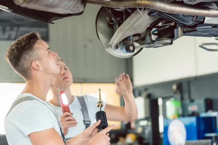 Mecánicos inspeccionando la amortiguación de un coche.